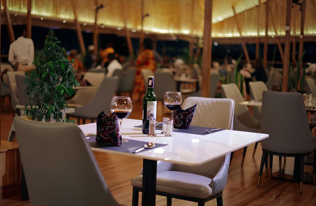 A beautifully decorated table with wine glasses set for a romantic Valentine’s dinner at The Hut, one of the best hotels in Kigali.