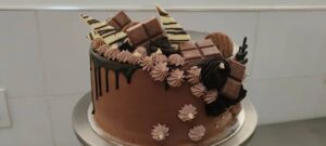 Elegant birthday cake in Kigali Rwanda, decorated with chocolate bars and artisanal frosting.