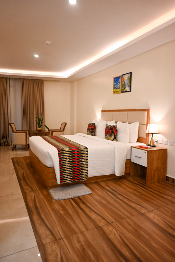 Spacious luxury suite at The Hut Hotel, featuring a king-size bed and modern decor, considered among the best rooms in Kigali.