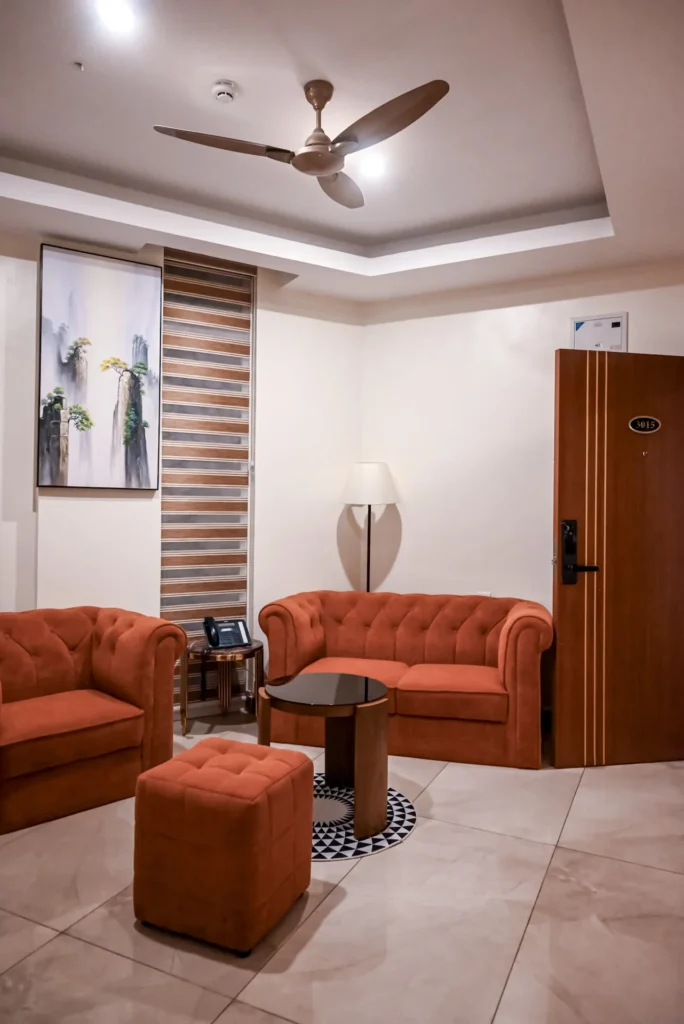 Junior Suite sitting area with ceiling fan and lounge seating at The Hut Hotel, Kigali