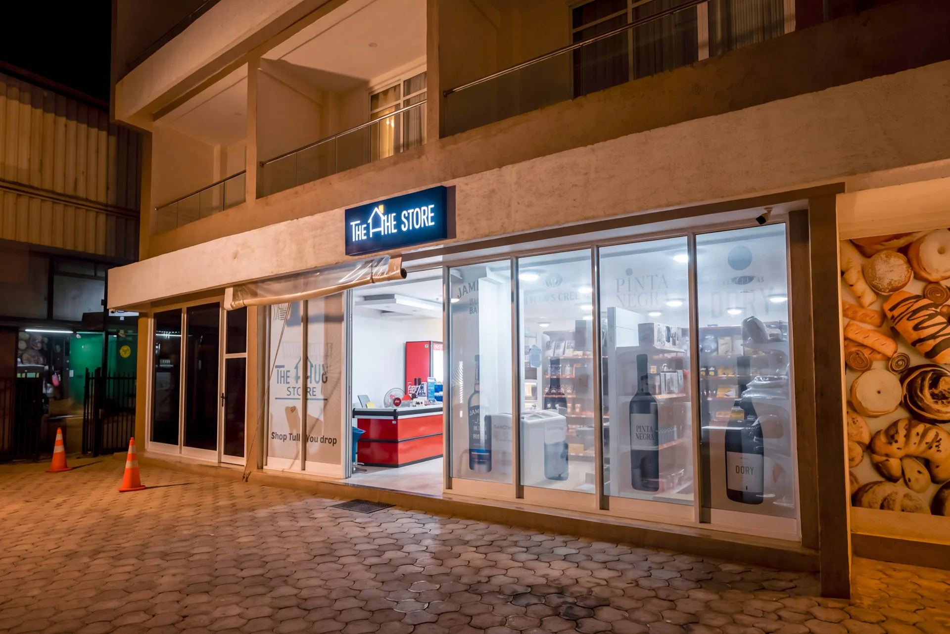 The Hut Store supermarket storefront at night in Kimihurura, Kigali