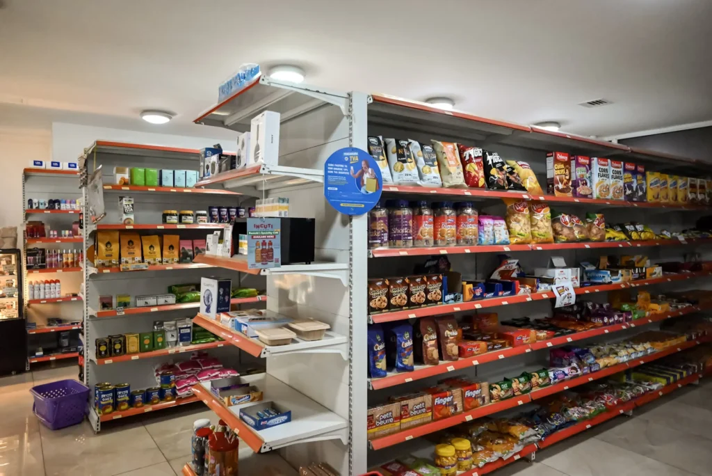 Stocked shelves of groceries and daily essentials inside The Hut Store supermarket, Kigali
